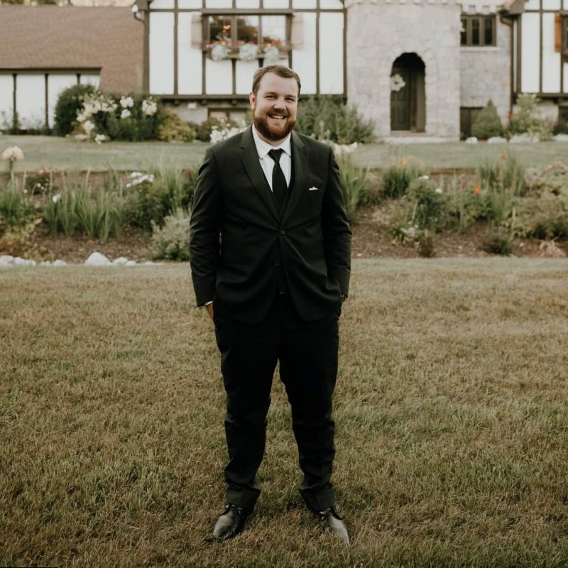 A portrait image of Josh, a Consultant with HRWise, gives a friendly and welcoming smile to the camera.